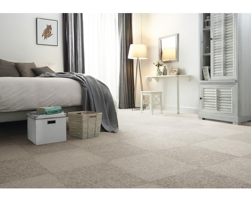 Schlafzimmer mit verlegtem Teppichboden aus einzelnen Teppichfliesen, Bett, Kommode und Sitzgelegenheit