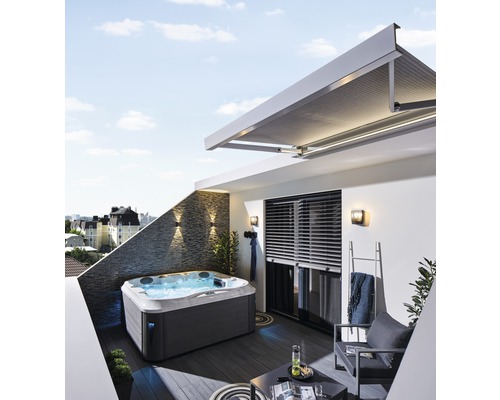 Jacuzzi sur un toit-terrasse avec coin salon et store