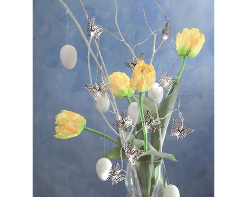 Dekorative Blumenvase mit Tulpen, Ästen, Schmetterlingen und Ostereiern