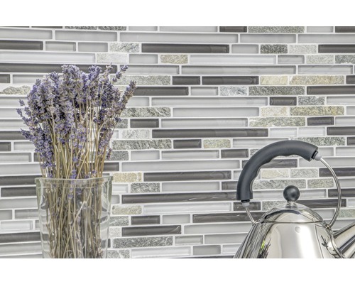 Mosaikfliesenwand mit Lavendelstrauß in Vase und Teekessel