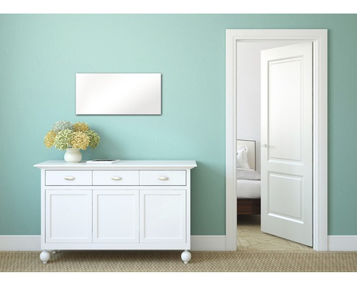 Espace de vie avec commode blanche, miroir et porte ouverte