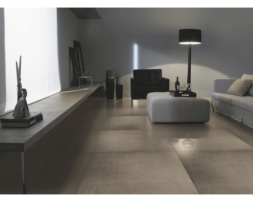 Wohnzimmer mit Bodenfliesen, Sofa, Sessel und Stehlampe.