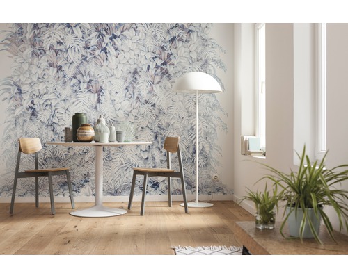 Wohnraum mit Fototapete mit Pflanzenmotiven, Esstisch und Stühlen.