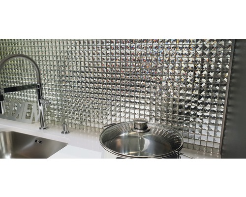 Scène de cuisine avec mur en mosaïque, évier, robinet et casserole