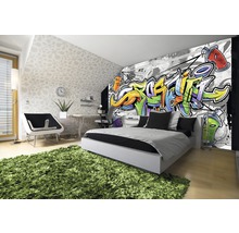 Chambre moderne avec papier peint graffiti, lit, bureau et tapis vert.