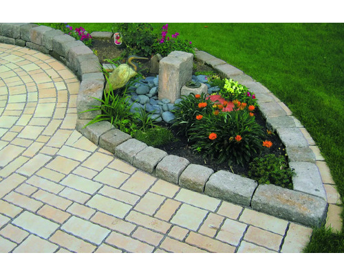 Jardin avec chemin de pierre et parterre de fleurs bordé de pierres