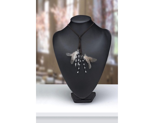 Halskette mit Federn und Perlen auf einer Schmuckpuppe