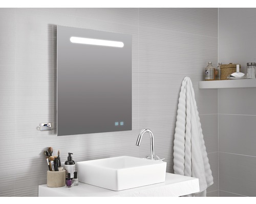 Badezimmer mit beleuchtetem Spiegelschrank, Waschbecken und Armatur