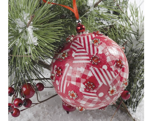 Boule de Noël avec motif et décorations sur branche de sapin