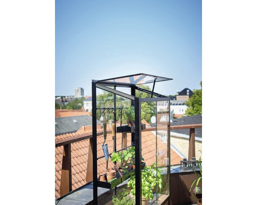 Gewächshaus mit Pflanzen und Gartengeräten auf einer Dachterrasse
