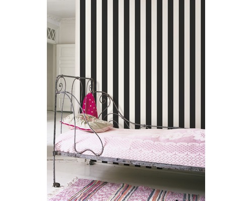 Schlafzimmer mit Bett vor Tapete mit vertikalen Streifen