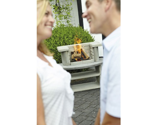 Cheminée d''extérieur en béton avec du bois qui brûle et deux personnes