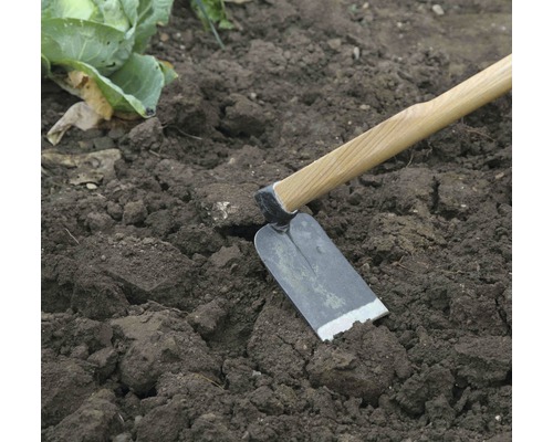 Gartenhacke mit Holzgriff im Gartenbeet