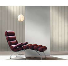 Raumansicht mit einer Liege, einer Stehlampe und einer Tapete mit Streifenmuster