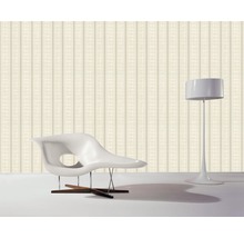 Tapete mit Streifenmuster, Sessel und Stehlampe in einem Raum.