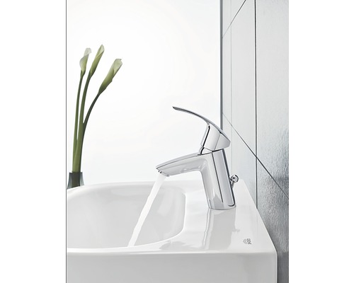 Glänzende Waschtischarmatur mit laufendem Wasser auf einem Waschbecken