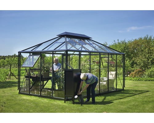 Serre avec plantes et deux personnes dans le jardin