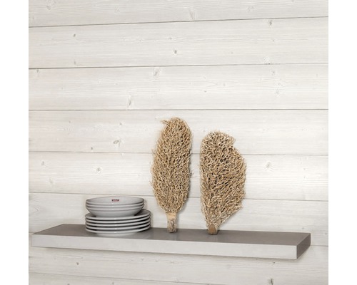 Branches décoratives et assiettes sur une étagère contre un mur en bois