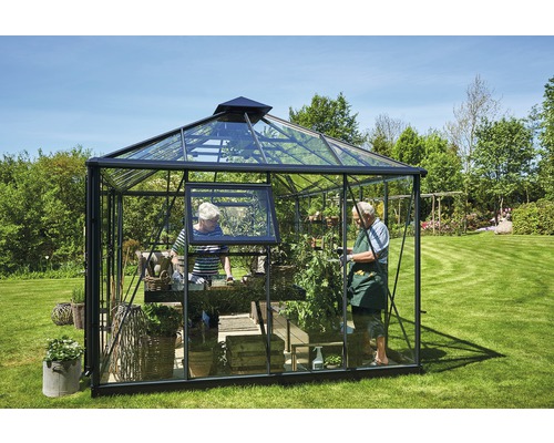 Serre avec des plantes et deux personnes dans le jardin