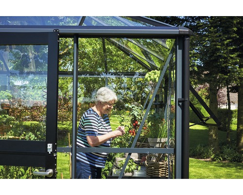 Serre avec femme faisant du jardinage dans la serre.