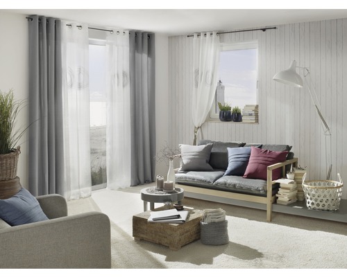 Wohnzimmer mit Sofa, Sessel, Vorhängen und dekorativen Elementen für ein gemütliches Ambiente.