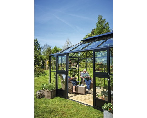 Serre avec murs en verre, chaises de jardin et personnes dans le jardin