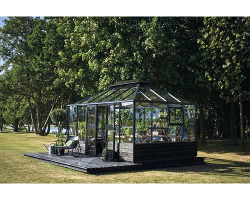 Serre sur terrasse en bois dans jardin avec arbres
