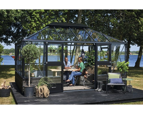 Serre avec des personnes sur une terrasse dans le jardin.