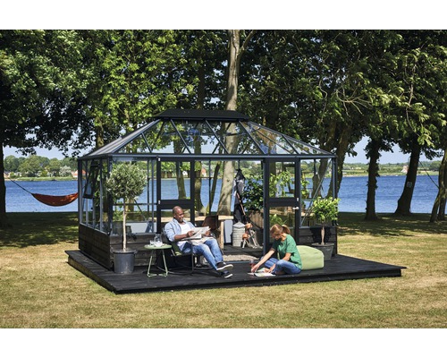 Serre avec des personnes sur une terrasse en bois dans le jardin