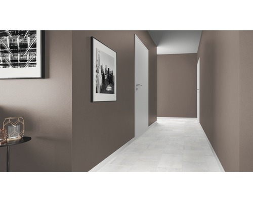 Couloir avec portes blanches, sol clair et photos encadrées aux murs