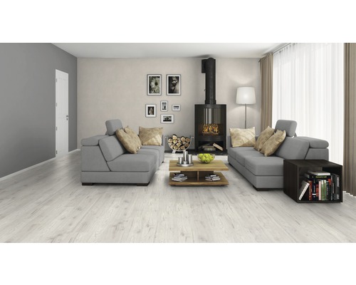 Heller Wohnraum mit Laminatboden, grauer Couchgarnitur und Kamin.