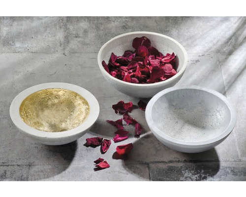 Trois coupes en béton, une tapissée d''or, une remplie de pétales de rose, une vide.