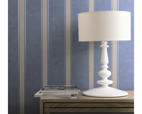 Papier peint décoratif à rayures derrière une lampe de table et des magazines