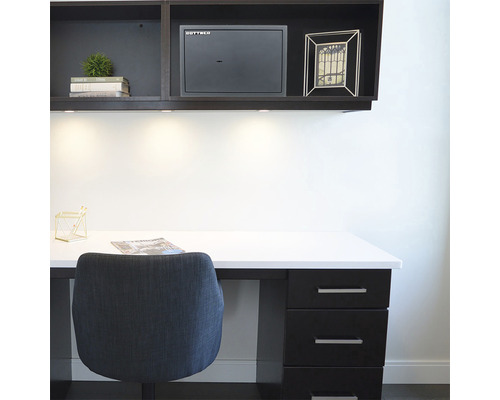 Schreibtisch mit Stuhl, Schubladen und einem Wandschrank mit Tresor