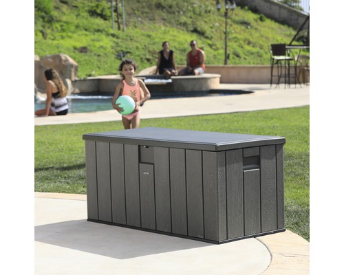 Graue Aufbewahrungsbox im Garten in der Nähe eines Pools.