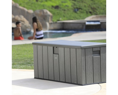 Graue Gartenbox aus Kunststoff mit Deckel vor Pool