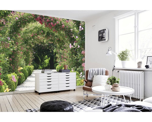 Salon lumineux avec papier peint photo allée de jardin, commode, fauteuil et table