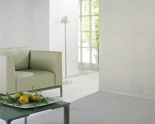 Salon lumineux avec fauteuil, lampadaire et papier peint à motifs.