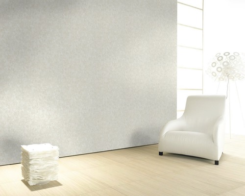 Pièce claire avec papier peint structuré, fauteuil et éclairage décoratif