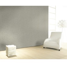 Pièce lumineuse avec mur gris, fauteuil blanc et pile de papier