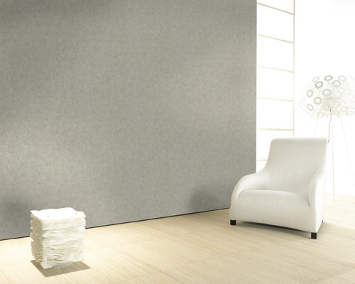 Pièce lumineuse avec mur gris, fauteuil blanc et pile de papier
