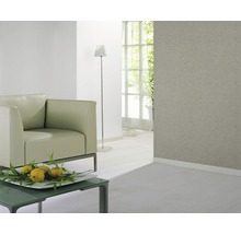 Salon lumineux avec fauteuil, lampadaire et papier peint texturé