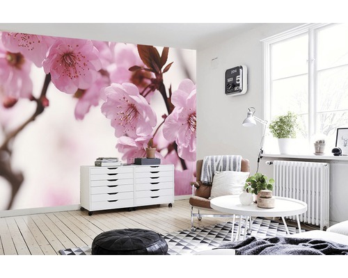 Wohnraum mit Fototapete mit Kirschblütenmuster, Kommode und Sitzgelegenheiten.