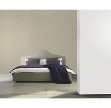 Chambre avec un lit et un papier peint à motifs.