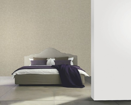 Chambre avec un lit et un papier peint à motifs.