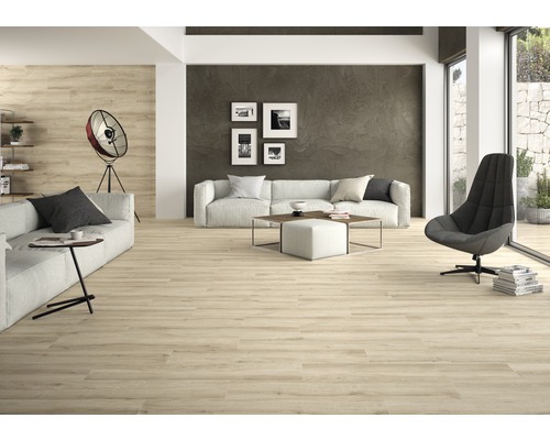 Heller Wohnraum mit Holzboden, Sofa, Sessel und Dekorationen