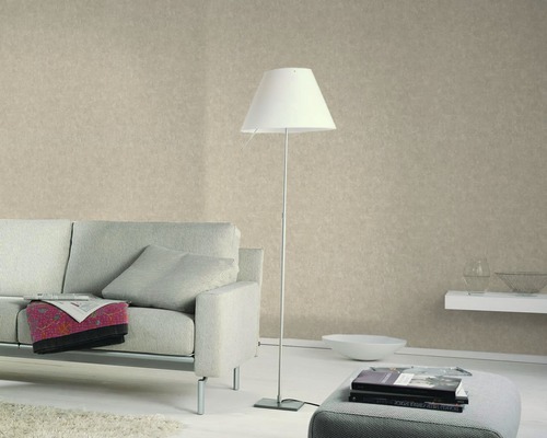 Salon avec canapé, lampadaire et papier peint à motifs pour une ambiance chaleureuse.