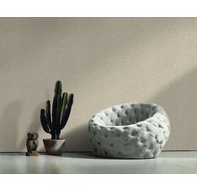 Scène avec fauteuil, cactus et figurine décorative devant un mur