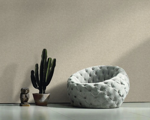 Scène avec fauteuil, cactus et figurine décorative devant un mur