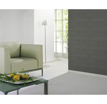 Wohnzimmer mit grauer gemusterter Tapete, Sessel, Stehlampe und Tisch